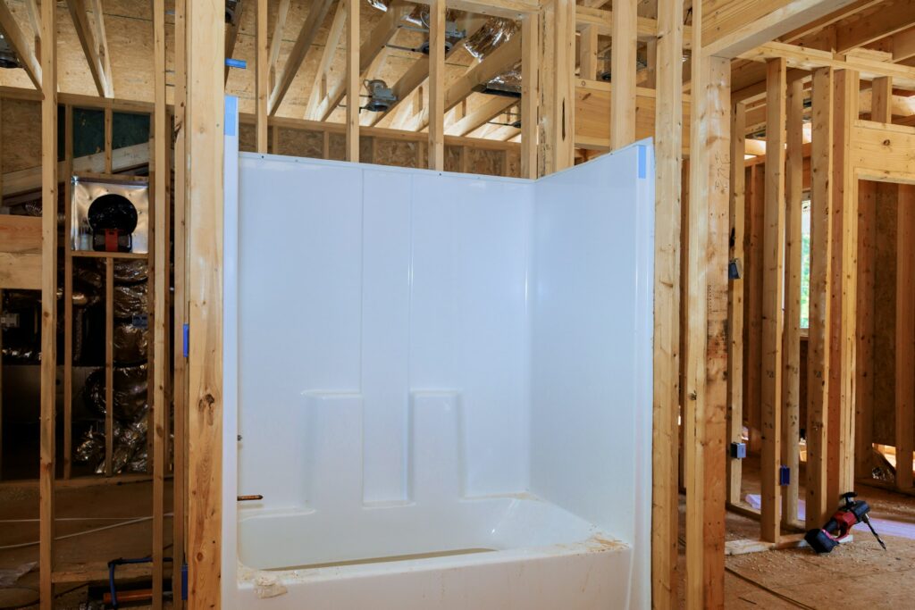 A acrylic bathtub installation with plumbing work in new house bathroom remodel